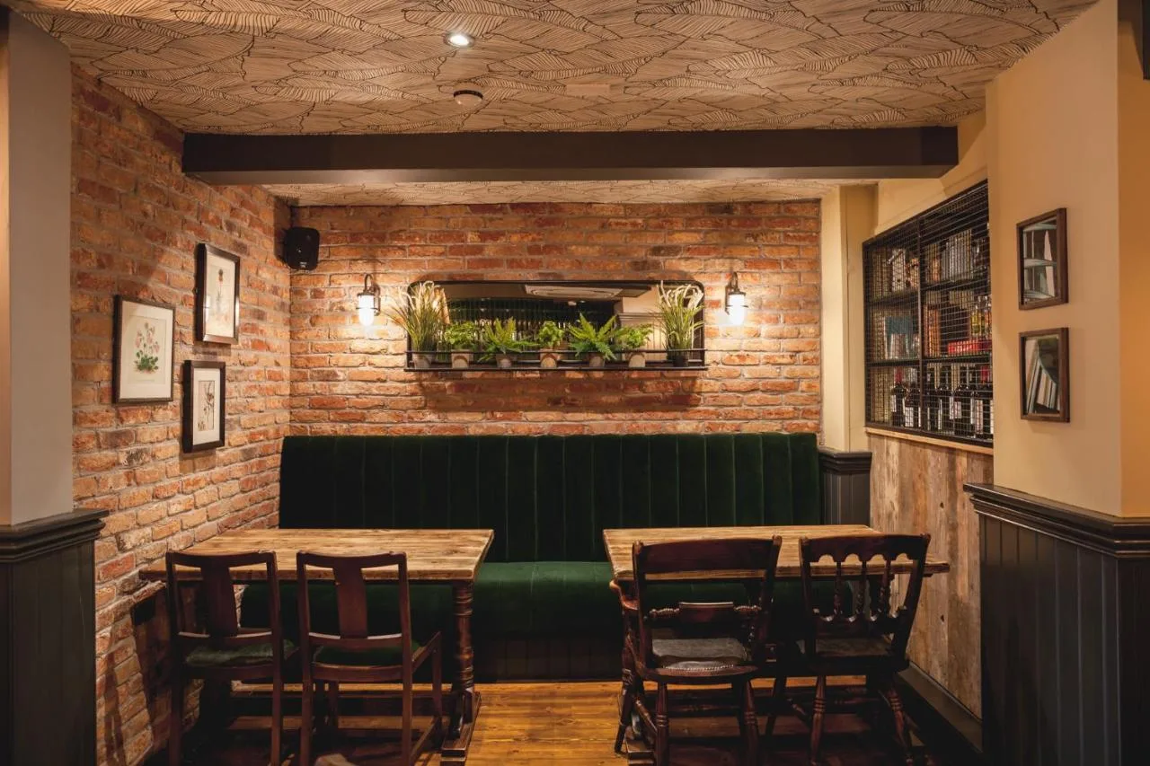 a restaurant with two tables and a green bench at Pontcanna Inn in Cardiff